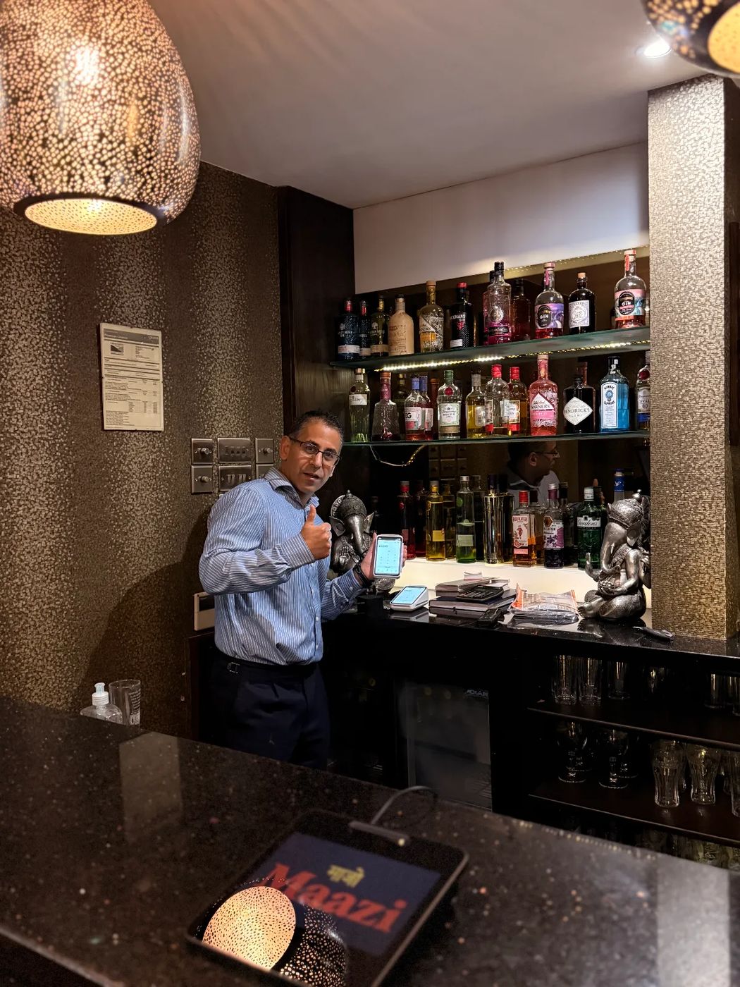 Maazi Indian Restaurant's owner in Hathersage with his new Square card machine at the bar