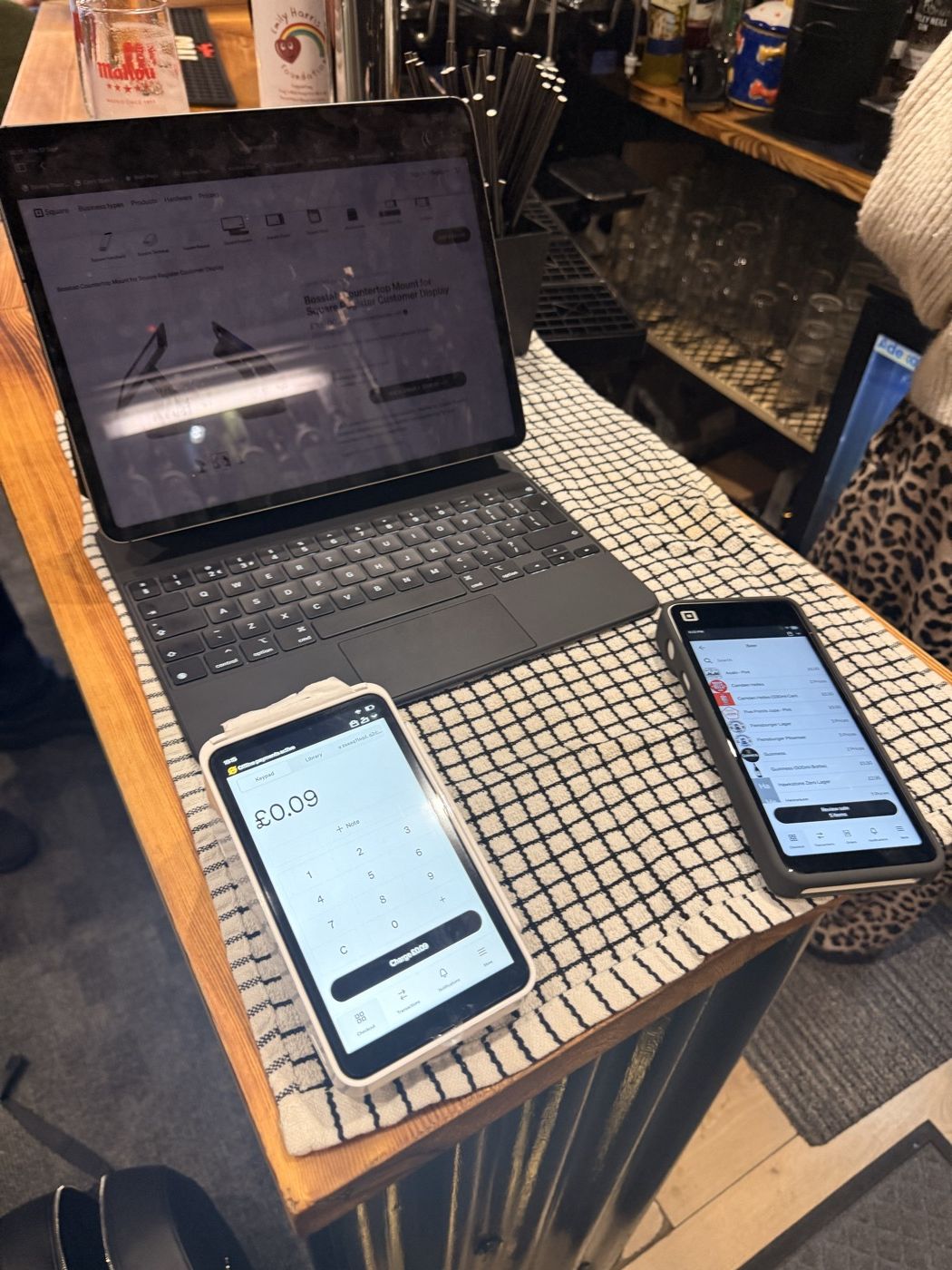 Square Point of Sale running on two phones behind a bar